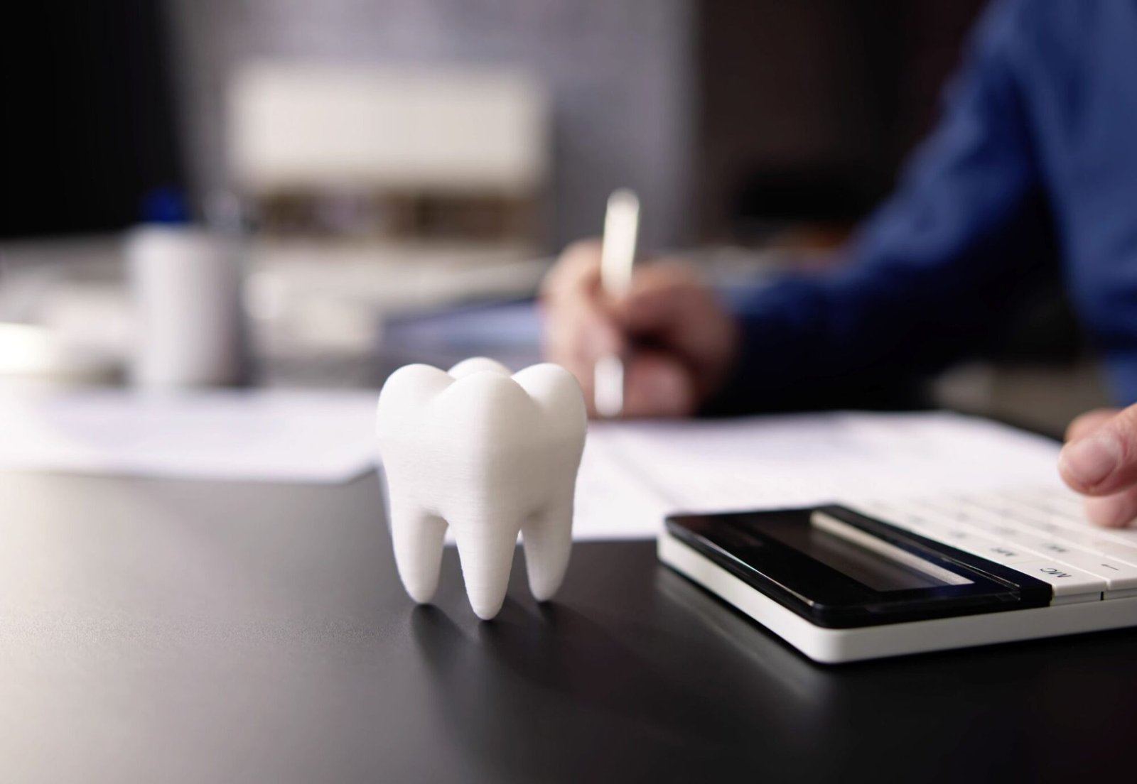 Dental treatment cost calculation with a tooth model and calculator on desk in Turkey