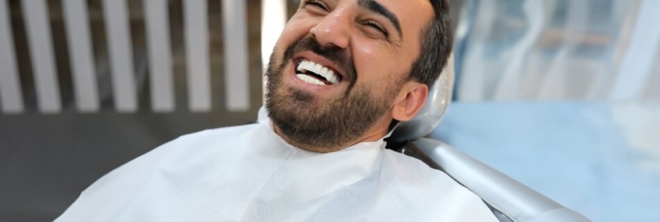 Smiling patient after Hollywood Smile treatment in dental chair